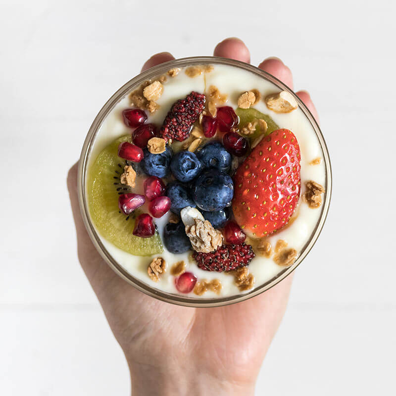 A bowl of yogurt with fruit and granola on top