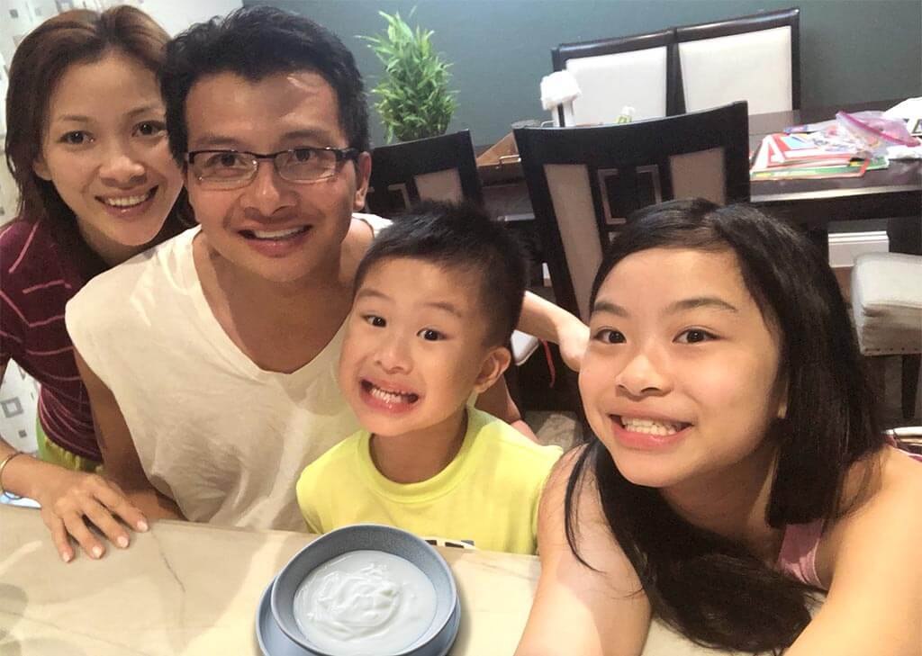 Nguyen family seated at a table enjoying yogurt.